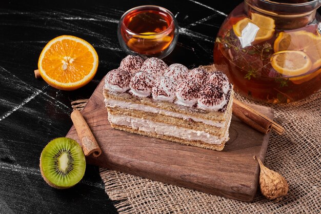 Slice of tiramisu on a wooden platter .