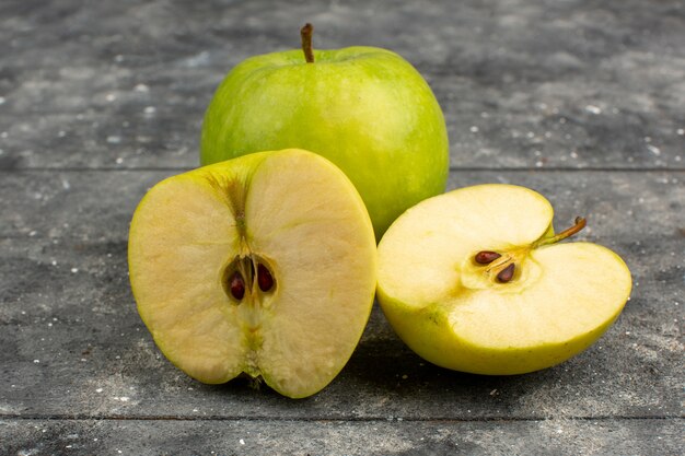 Sliced apples green mellow ripe on a grey