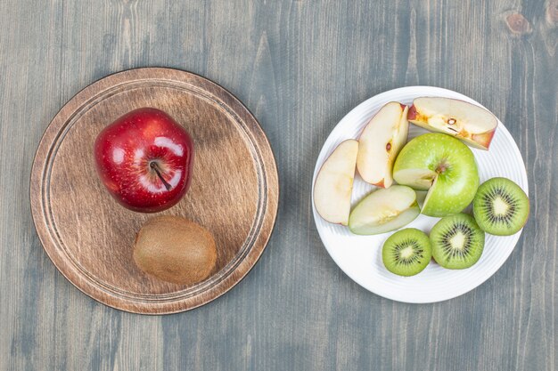 Mele a fette con kiwi fresco su un tavolo di legno