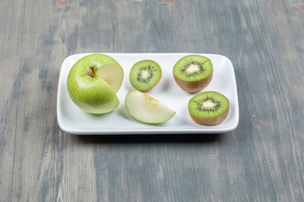 Sliced apples with fresh kiwi on a wooden table