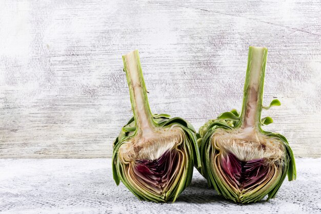 Sliced artichoke on a light gray . side view.