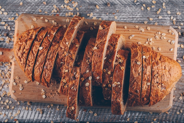 Нарезанный хлеб на разделочную доску на деревянной поверхности