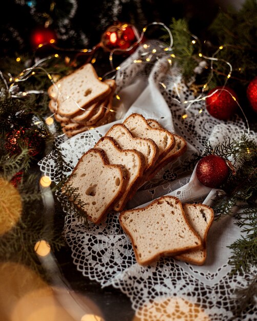 Нарезанный хлеб и новогодние игрушки на столе