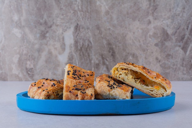 Free photo sliced bread with sesame on the wooden plate on the dark surface