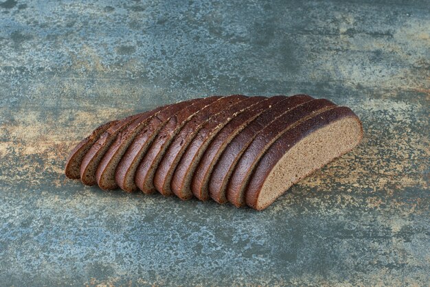 Sliced brown bread on marble background