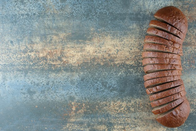 Sliced brown bread on marble background