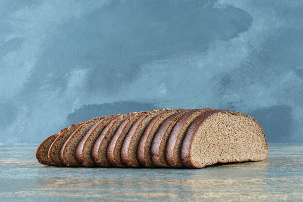 Sliced brown bread on marble background