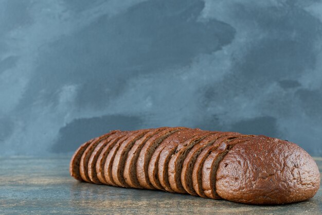 大理石の背景にスライスした茶色のパン