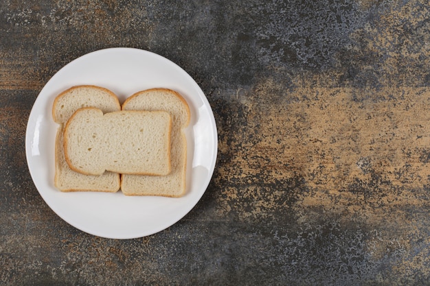 Sliced brown bread on white plate. 