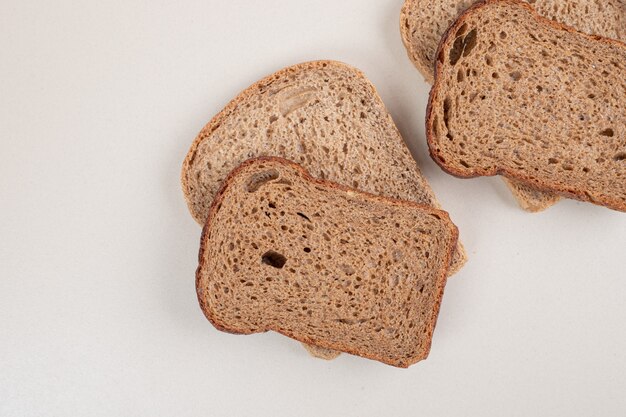 Sliced brown bread on white surface