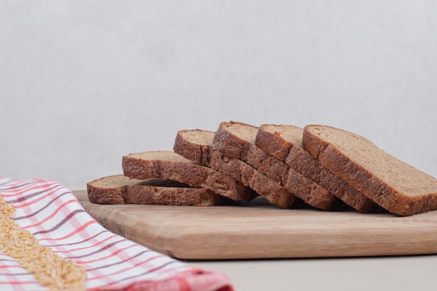 Fette di pane marrone su tavola di legno. foto di alta qualità