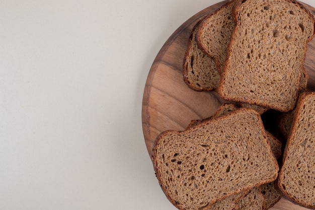 Sliced brown bread on wooden plate. High quality photo