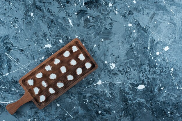 青いテーブルの上で、ボード上のスライスされたキャンディー。