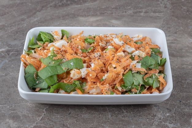 Sliced carrot salad on white plate.