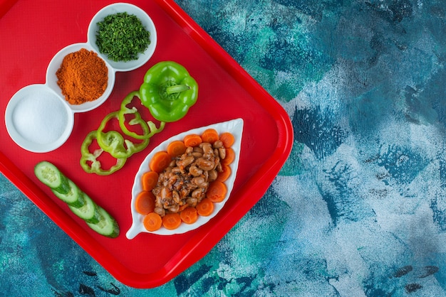 무료 사진 블루 테이블에 쟁반에 접시에 당근, 콩, 야채를 썰어.