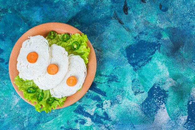 Sliced carrots, cabbage and lettuce leaves on a plate 