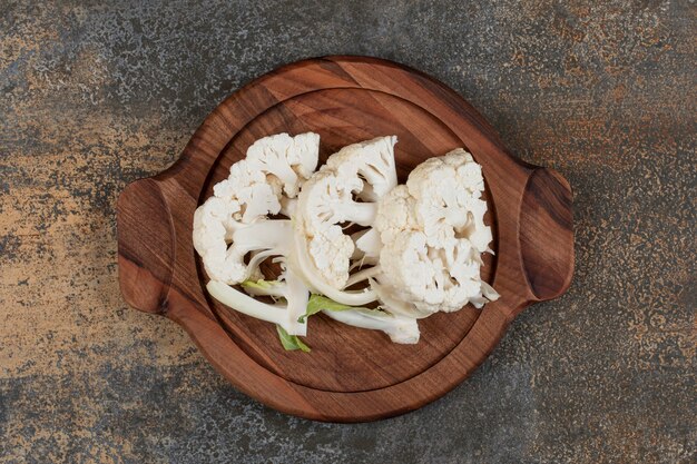 Free photo sliced cauliflower arrangement on board, on the marble surface