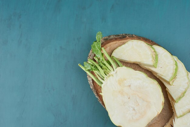 Sliced celery corn on blue on a wooden board.