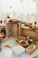 Free photo sliced cheese and meat served on plate with olivas stand on wooden boxes