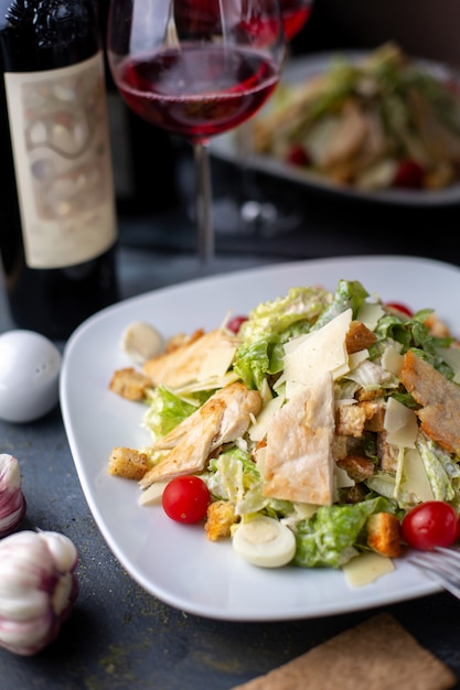 Foto gratuita pezzi di pollo a fette insieme con vino rosso di verdure fresche all'interno del piatto bianco