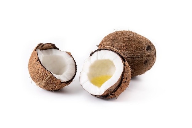 sliced coconuts with oil inside isolated on white background