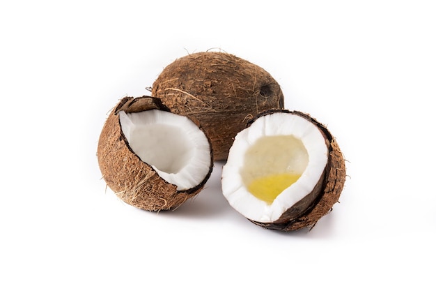 sliced coconuts with oil inside isolated on white background