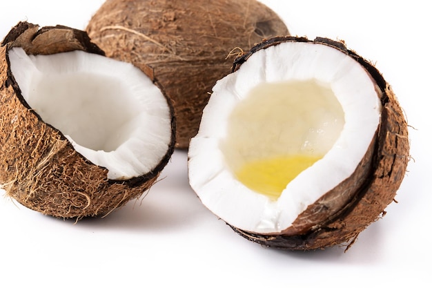 sliced coconuts with oil inside isolated on white background