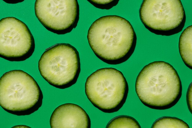 Sliced cucumber pattern on a green background