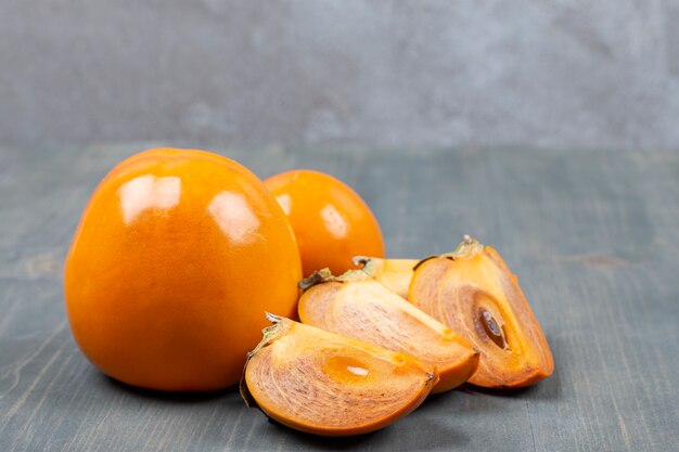 Sliced delicious persimmon in a wooden table