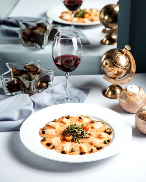 Foto gratuita pesce a fette con formaggio e bicchiere di vino