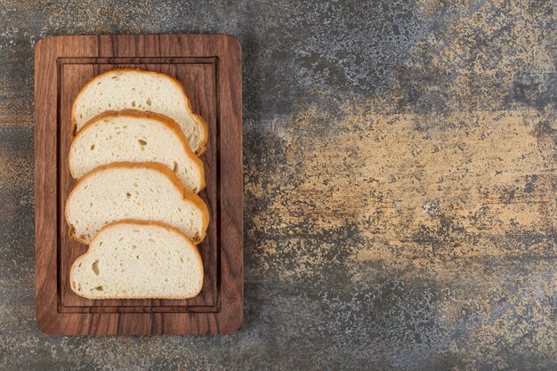 Sliced fragrant bread on wooden board