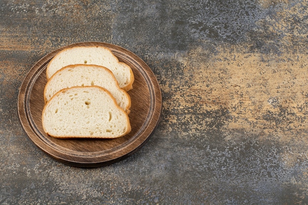 Sliced fragrant bread on wooden cutting board