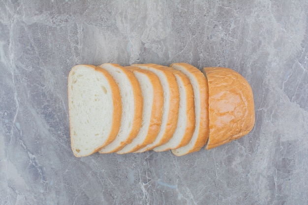 Sliced of fresh bread on marble background.