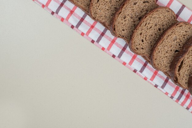 Sliced fresh brown bread on tablecloth. High quality photo