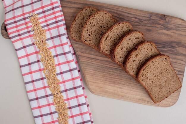 Sliced fresh brown bread on wooden board