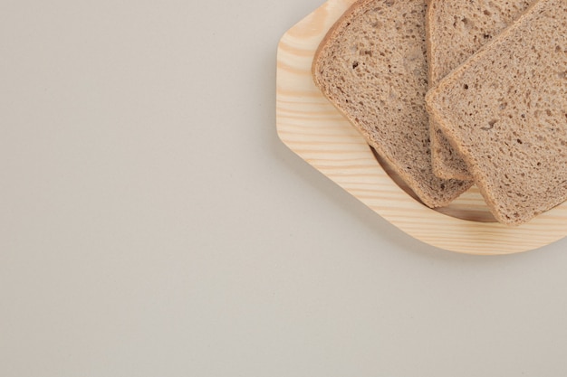 Нарезанный свежий черный хлеб на деревянной тарелке