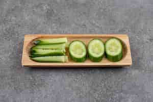 Free photo sliced fresh cucumbers on wooden board