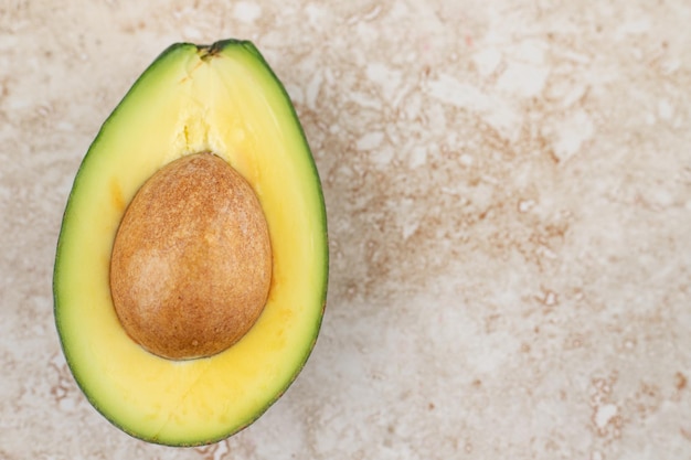 Sliced fresh delicious avocado on marble background.