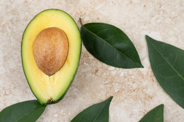 Sliced fresh delicious avocado on marble background.