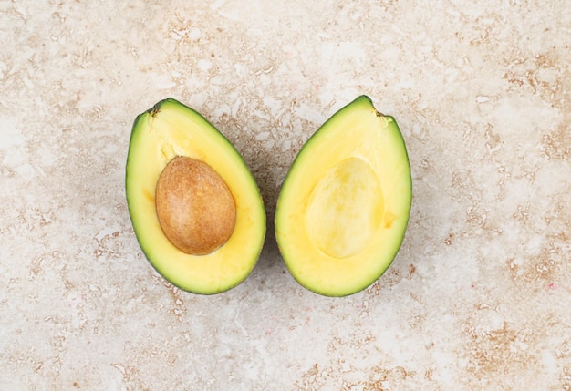 Sliced fresh delicious avocado on marble surface