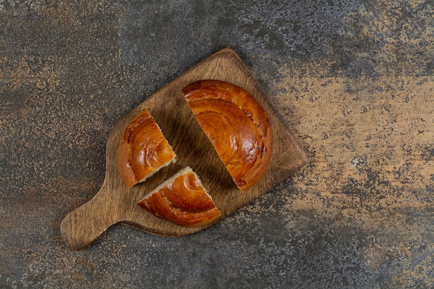 Sliced fresh pastry on wooden board.