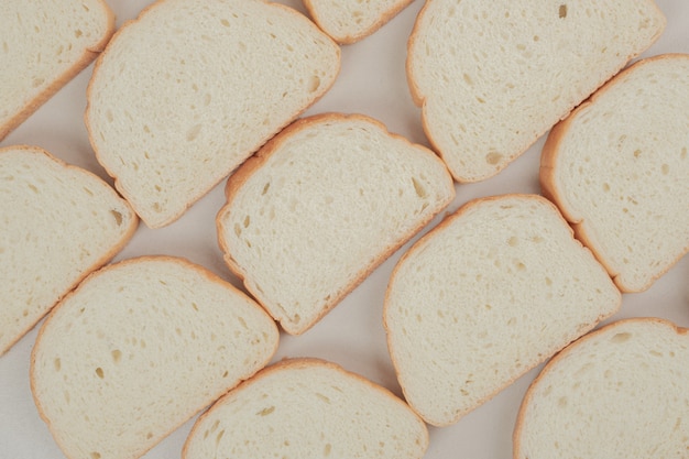 Pane bianco fresco affettato sulla superficie bianca