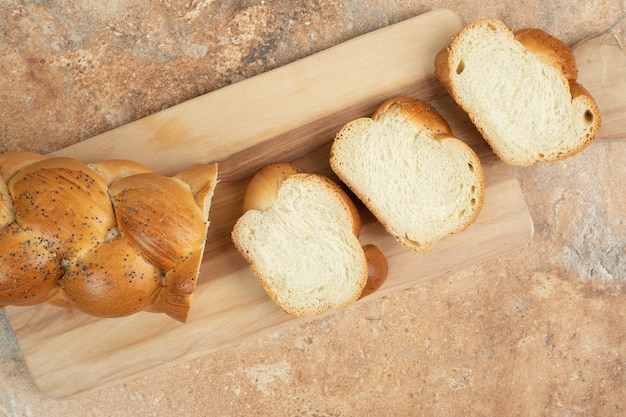 Sliced fresh white bread on wooden cutting board.