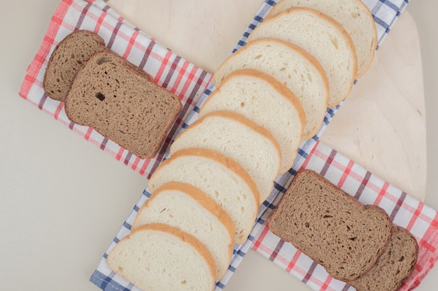 Free photo sliced fresh white and brown bread on tablecloth