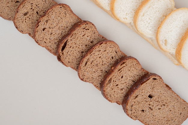 Free photo sliced fresh white and brown bread on white surface