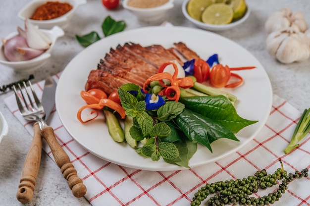 Sliced ÃÂÃÂ¢ÃÂÃÂÃÂÃÂÃÂÃÂ¢ÃÂÃÂÃÂÃÂfried pork with lemon, onion, red onion, tomato, long bean, butterfly pea flower, and mint.