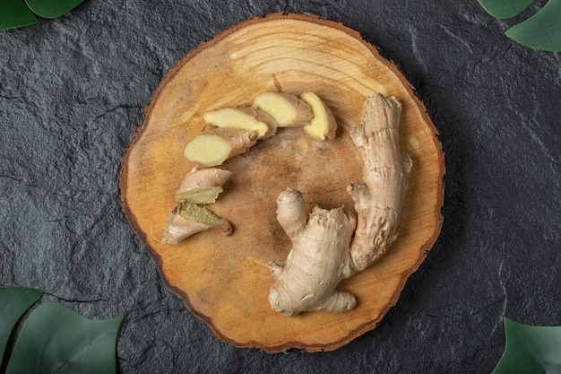 Free photo sliced ginger roots on wooden piece