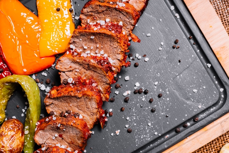 Free Photo sliced grilled steak on the wooden board pepper tomato sea salt top view