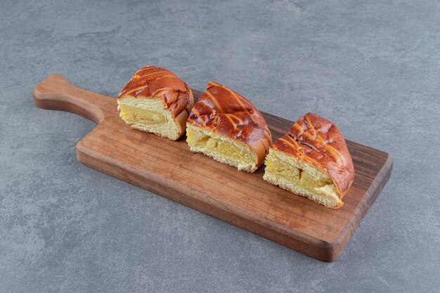 Sliced homemade fresh pastries on wooden board.