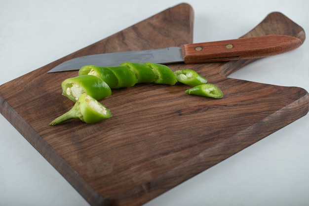 Sliced hot chili pepper on wooden chopping board.